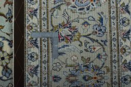 Backside of handmade 2000s Kashan rug showing knot structure and weave density