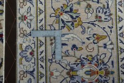 Backside of handmade 2000s Kashan rug showing knot structure and weave density