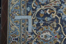 Backside of handmade 2000s Kashan rug showing knot structure and weave density