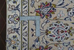 Backside of handmade 2000s Kashan rug showing knot structure and weave density