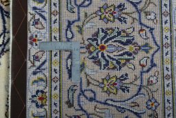 Backside of handmade 2000s Kashan rug showing knot structure and weave density