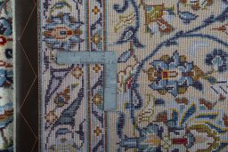 Backside of handmade 2000s Kashan rug showing knot structure and weave density