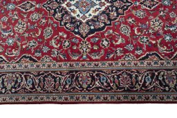 Corner detail of 2000s Kashan rug showing border pattern and Wool pile