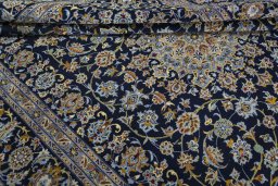 Corner detail of 2000s Kashan rug showing border pattern and Wool pile