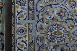Backside of handmade 2000s Kashan rug showing knot structure and weave density