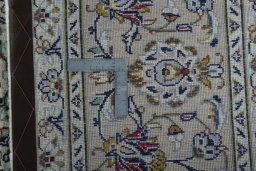 Backside of handmade 2000s Kashan rug showing knot structure and weave density