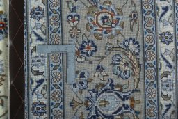 Backside of handmade 2000s Kashan rug showing knot structure and weave density
