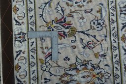 Backside of handmade 2000s Kashan rug showing knot structure and weave density