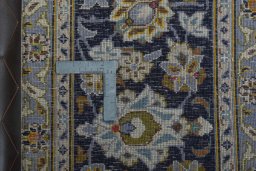 Backside of handmade 2000s Kashan rug showing knot structure and weave density