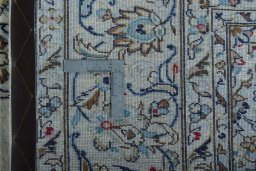 Backside of handmade 2000s Kashan rug showing knot structure and weave density