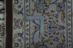 Backside of handmade 2000s Kashan rug showing knot structure and weave density
