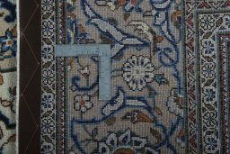 Backside of handmade 2000s Kashan rug showing knot structure and weave density