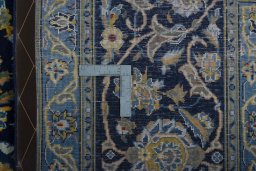 Backside of handmade 2000s Kashan rug showing knot structure and weave density