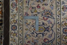 Backside of handmade 2000s Kashan rug showing knot structure and weave density