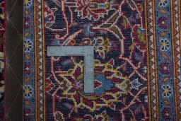 Backside of handmade 2000s Kashan rug showing knot structure and weave density