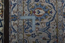 Backside of handmade 2000s Kashan rug showing knot structure and weave density