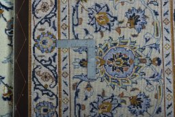 Backside of handmade 2000s Kashan rug showing knot structure and weave density