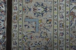 Backside of handmade 2000s Kashan rug showing knot structure and weave density