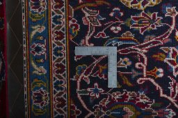 Backside of handmade 2000s Kashan rug showing knot structure and weave density