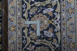 Backside of handmade 2000s Kashan rug showing knot structure and weave density