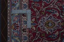 Backside of handmade 2000s Kashan rug showing knot structure and weave density