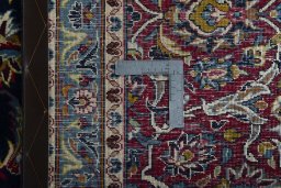 Backside of handmade 2000s Kashan rug showing knot structure and weave density