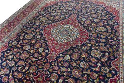 Backside of handmade 2000s Kashan rug showing knot structure and weave density