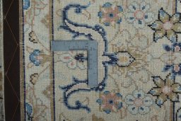 Backside of handmade 2000s Kashan rug showing knot structure and weave density