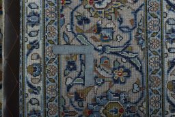 Backside of handmade 2000s Kashan rug showing knot structure and weave density