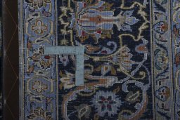 Backside of handmade 2000s Kashan rug showing knot structure and weave density