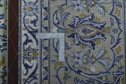 Backside of handmade 2000s Kashan rug showing knot structure and weave density