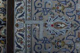 Backside of handmade 2000s Kashan rug showing knot structure and weave density