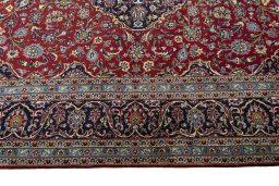 Corner detail of 2000s Kashan rug showing border pattern and Cork pile