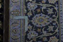 Backside of handmade 2000s Kashan rug showing knot structure and weave density