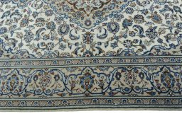 Corner detail of 2000s Kashan rug showing border pattern and Wool pile