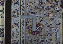 Backside of handmade 2000s Kashan rug showing knot structure and weave density