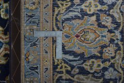 Backside of handmade 2000s Kashan rug showing knot structure and weave density