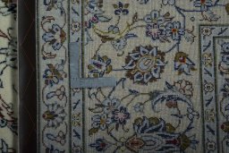 Backside of handmade 2000s Kashan rug showing knot structure and weave density