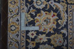 Backside of handmade 2000s Kashan rug showing knot structure and weave density