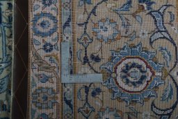 Backside of handmade 2000s Kashan rug showing knot structure and weave density