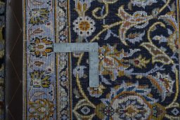 Backside of handmade 2000s Kashan rug showing knot structure and weave density