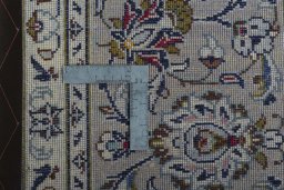 Backside of handmade 2000s Kashan rug showing knot structure and weave density