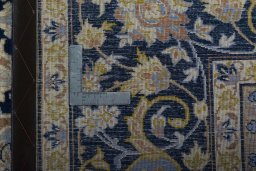 Backside of handmade 2000s Kashan rug showing knot structure and weave density