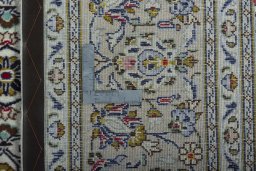 Backside of handmade 2000s Kashan rug showing knot structure and weave density