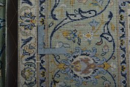 Backside of handmade 2000s Kashan rug showing knot structure and weave density