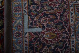 Backside of handmade 2000s Kashan rug showing knot structure and weave density