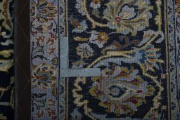 Backside of handmade 2000s Kashan rug showing knot structure and weave density