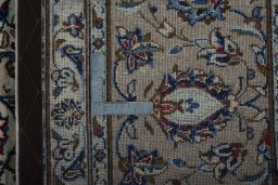 Backside of handmade 2000s Kashan rug showing knot structure and weave density