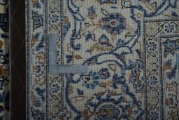 Backside of handmade 2000s Kashan rug showing knot structure and weave density