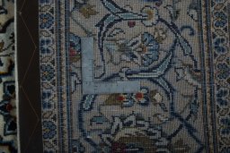 Backside of handmade 2000s Kashan rug showing knot structure and weave density
